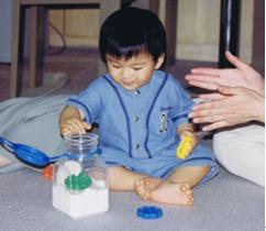 小孩把玩具放入盒