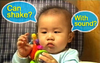 Baby exploring a rattle, thinking if this can be shaken and make sound